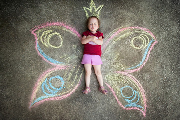 Little girl Butterfly, CAPRICE. Drawing with chalk on the pavement