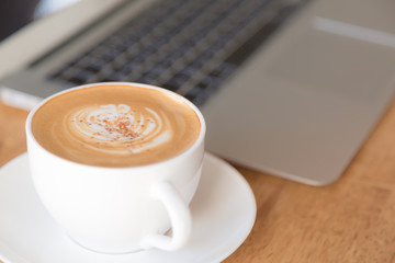 laptop with coffee cup on old wooden table ( Filtered image proc
