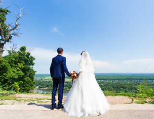 bride and groom standing back