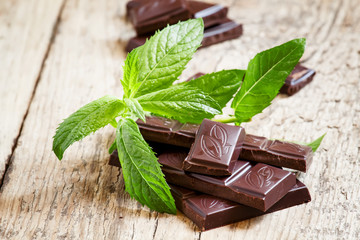 Dark chocolate with mint on an old wooden table, selective focus