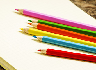 Pink school notebook in the box and colored pencils, selective f