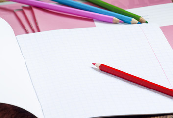Pink school notebook in the box and colored pencils, selective f
