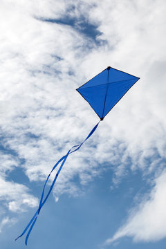 Blue Kite Flying In A Beautiful Sky Clouds