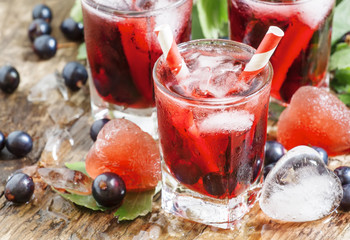 Fresh blackcurrant drink with berries and ice in a heart shape,
