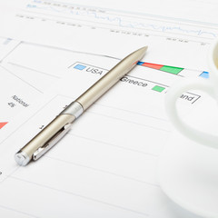 Pen and coffee cup financial charts - close up shot