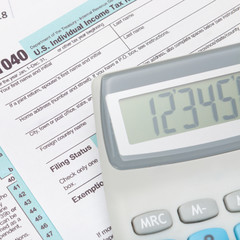 Calculator over US 1040 Tax Form - close up