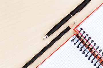 Office table with blank notepad, pen and pencil