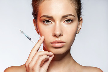 Young woman with cosmetic injections in the syringe