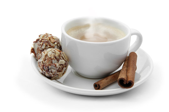 cup of coffee with chocolate candies and cinnamon