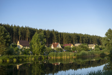River house with reflections and blue sky near the forest