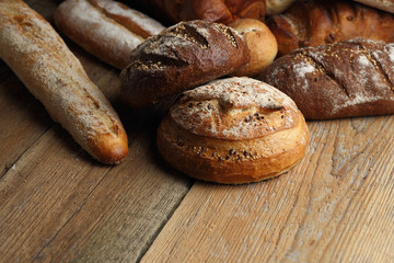 Assortment of fresh bread on a wooden background