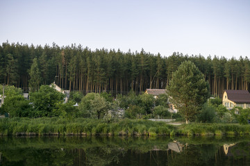 Fototapeta premium River house with reflections and blue sky near the forest