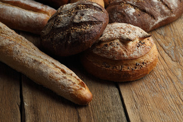 Assortment of fresh bread on a wooden background