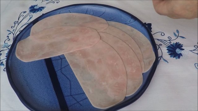 Ham slices isolated on a blue plate
