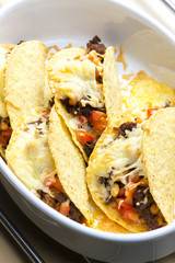 baked tacos filled with minced beef meat, beans and tomatoes