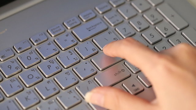 hand pressing the enter button in laptop keyboard
