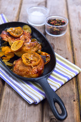 Delicious baked chicken thighs with lemon slices, onion and zucchini 