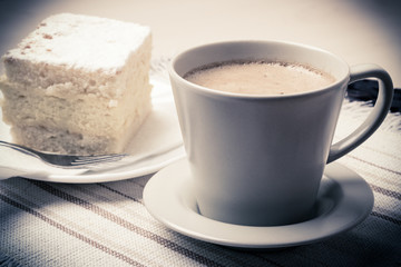 cup with coffee and cake on table
