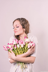 girl hugging on a white background of tulips on a white backgrou