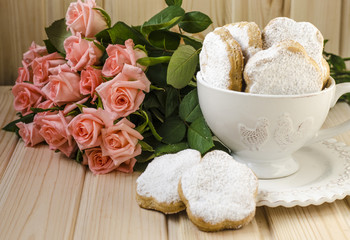 Spanish cookies for fat in a cup with a bouquet of roses 