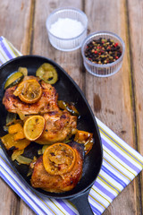 Delicious baked chicken thighs with lemon slices, onion and zucc