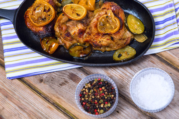 Delicious baked chicken thighs with lemon slices, onion and zucc