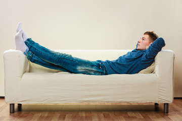 Young pensive man relaxing on couch