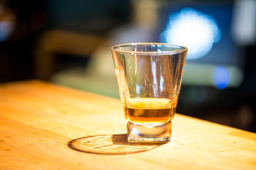 Glass of scotch whiskey on wooden background with copyspace