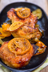 Delicious baked chicken thighs with lemon slices, onion and zucchini