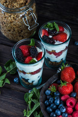 Homemade parfait with fresh fruit and cream on wooden background