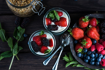 Homemade parfait with fresh fruit and cream on wooden background