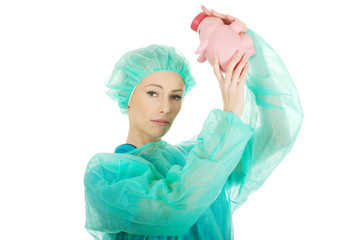 Worried doctor with pink piggy bank.