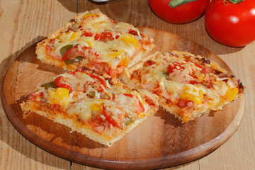 Pizza mit Paprika, Tomaten, Schinken, Zwiebeln, Käse