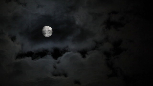 Full moon behind clouds at night