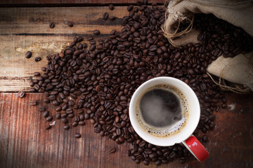 Coffee cup and saucer on a wooden table. Dark background.