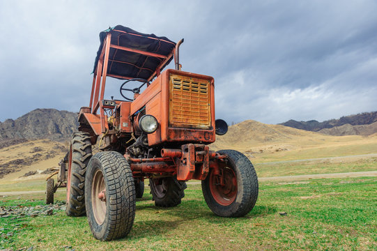 Lonely old tractor in Altai steppe in rainy day