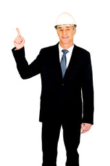 Smiling businessman with hard hat pointing up
