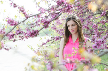 Beautiful fit lady between blossom tree in purple color