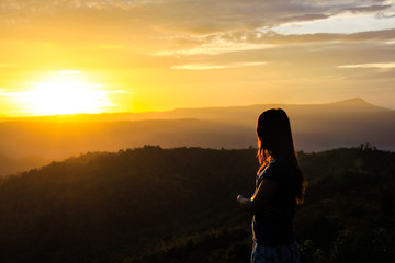 Woman standing mountain watching the sunrise