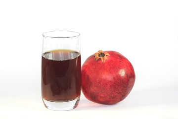 Glass of fresh pomegranate juice and ripe pomegranate