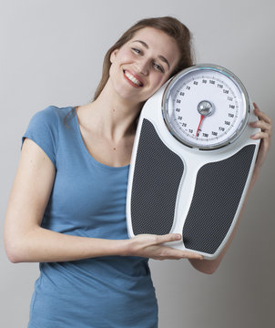 thrilled young woman in love with her weighting scale