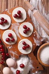 cooking dumplings with cherries close-up vertical top view
