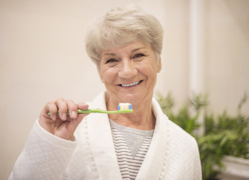Senior woman brushing her teeth