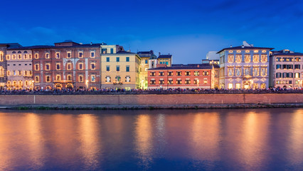 Fototapeta na wymiar Pisa, Italy. City buildings along river Arno at dusk