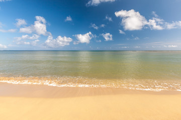 Fototapeta na wymiar Beach on tropical island. Clear blue water, sand, clouds. 