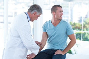 Fototapeta premium Doctor examining his patients arm