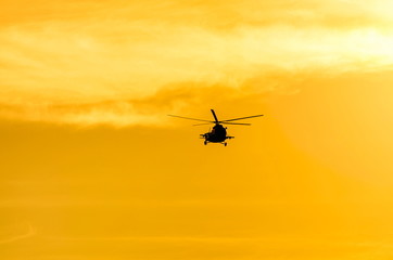 Fototapeta na wymiar Mi-8 helicopter in the background of the golden sky