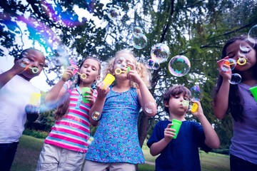 Children playing with bubble wand in the park