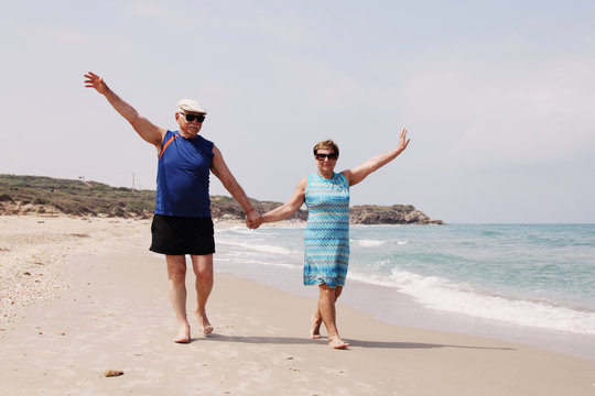 senior couple walking on the beach