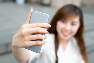 asian beautiful young woman using mobile phone to take selfie ou